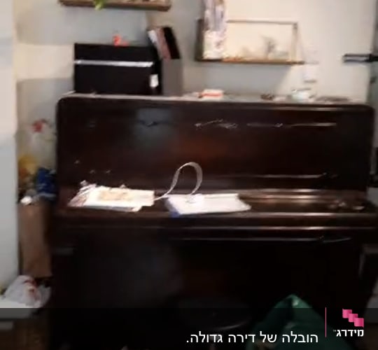 פסנתר עם חפצים, נעליים וסל על הרצפה